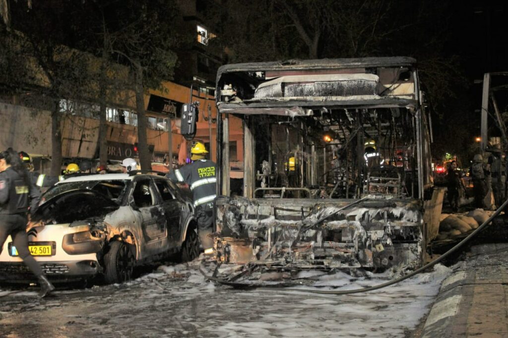 Bus and car burnt out after rocket hit in Holon Photo by Yoav Keren