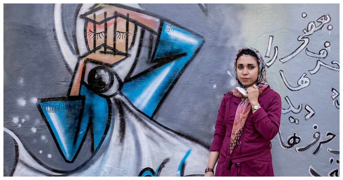 الأفغانية شمسيا حساني بجانب إحدى رسوماتها الجدارية