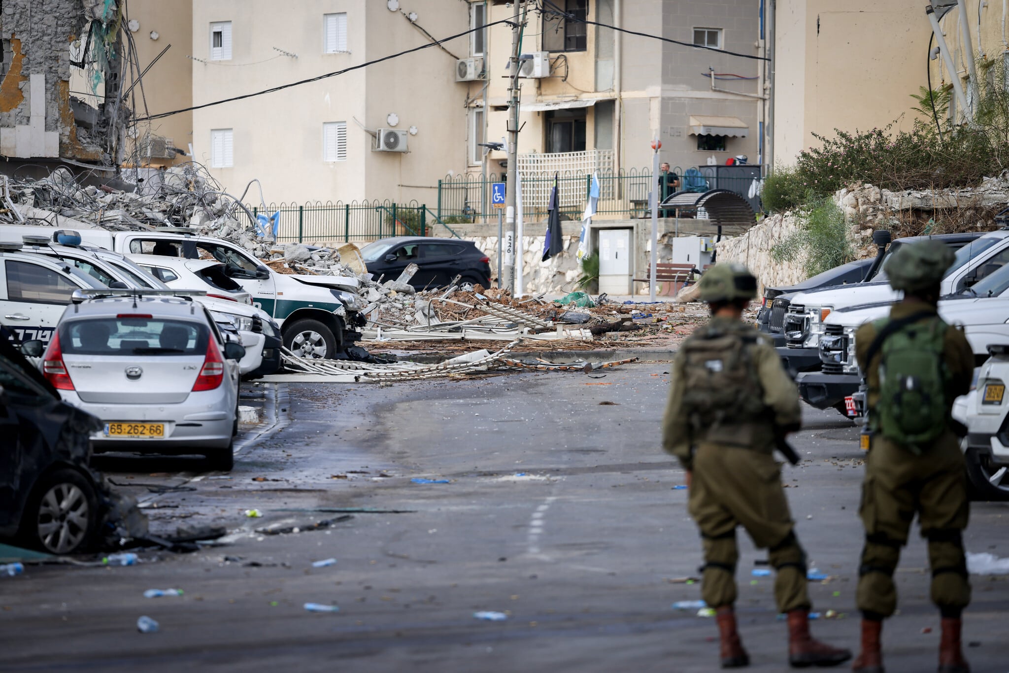 قوات إسرائيلية بجوار سيارة محترقة ومبنى منهار في سديروت بعد هجوم حماس